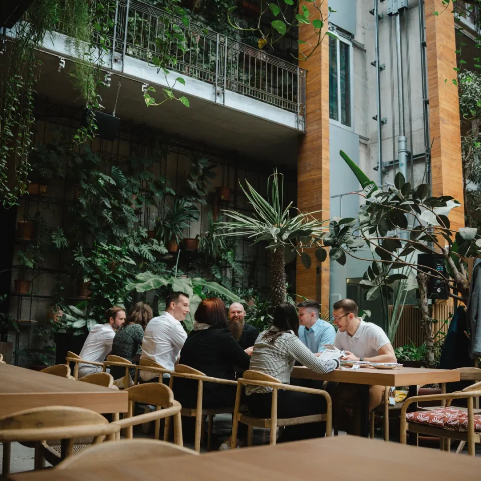 Team von public.consulting im Gespräch an einem Tisch in einem begrünten Innenhof